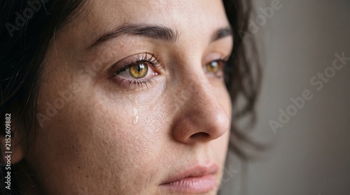 Close-up portrait of a distressed young woman crying with tears in her eyes representing sorrow and sadness