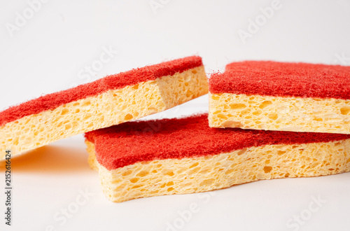Stack of red and yellow kitchen sponges isolated on white background.