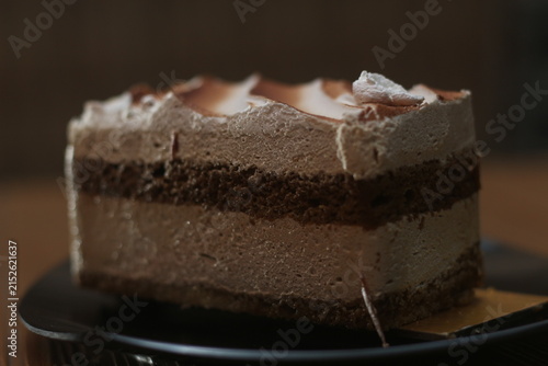 Bild auf Leinwand Rich Chocolate Cake Slice on Dark Plate in Warm Lighting