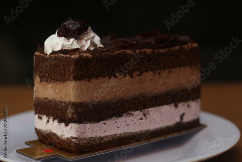 Foto Rich Chocolate Cake Slice with Whipped Cream and Cherry on Top in Plate