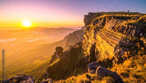 Golden hour sunrise over massive rocky mountain ridge.