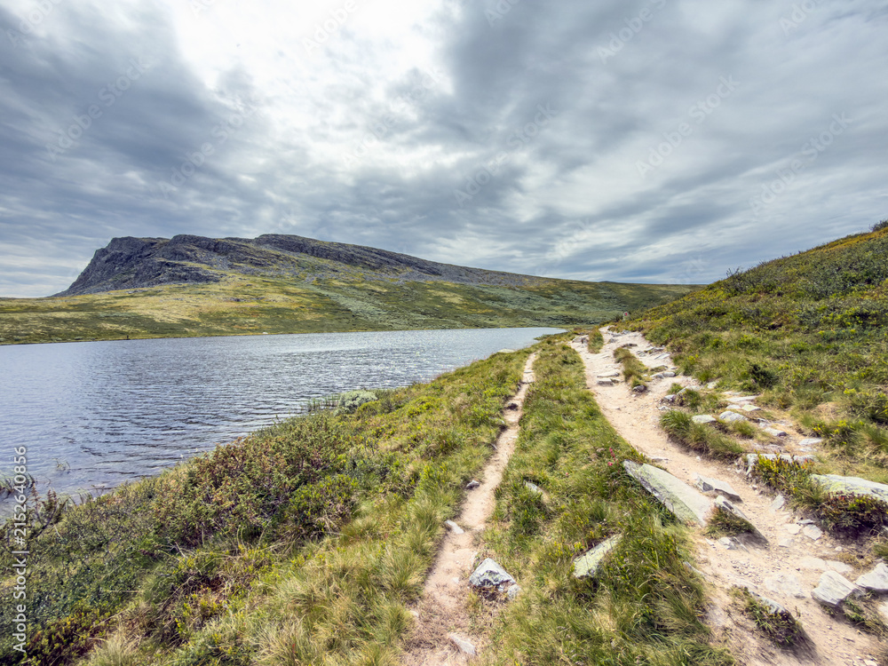 Fototapeta premium Sandy footpath beside a mountain lake in Rondane, Norway