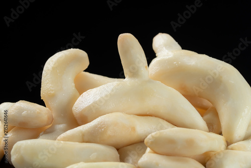 Pile of fresh peeled white turmeric on black background.