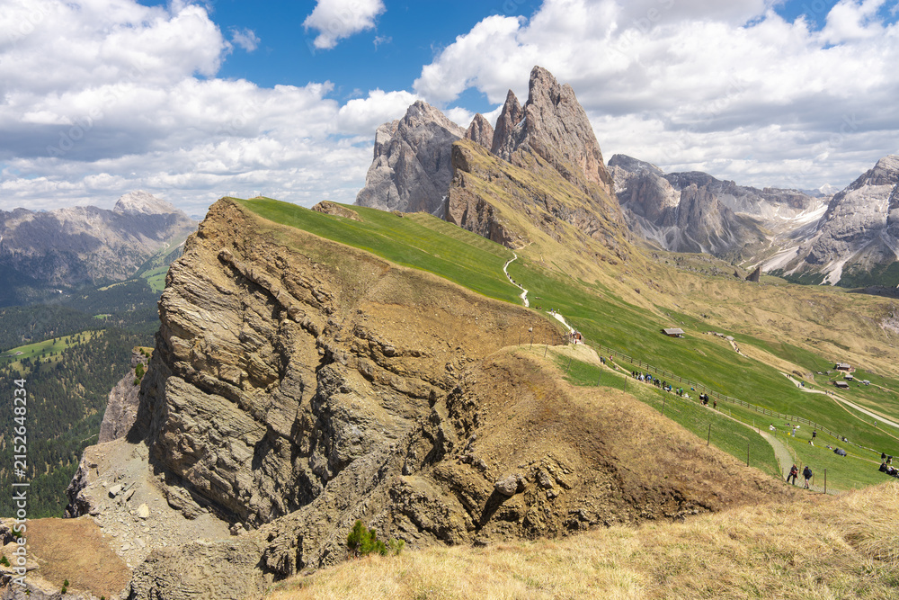 Naklejka premium Seceda mountain ridge with sharp rocky peaks and green grassy slopes in Italian Dolomites under blue sky, scenic alpine summer landscape of Odle Geisler mountains