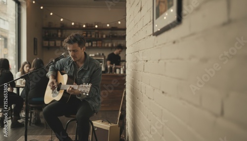 Musician Playing Acoustic Guitar During Live Cafe Performance