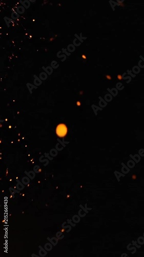 Glowing orange sparks floating against a dark background