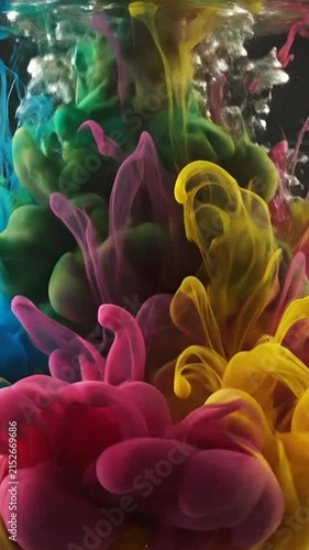 Colorful paint clouds mixing in clear liquid with dramatic lighting effects