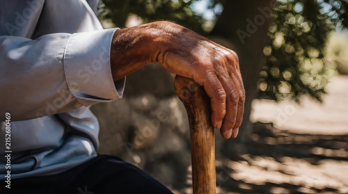 Elderly Mans Hand Resting on Wooden Cane with Textured Details