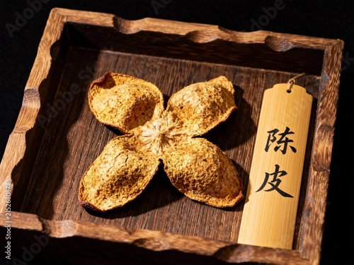 dried chinese medicinal herb in wooden tray