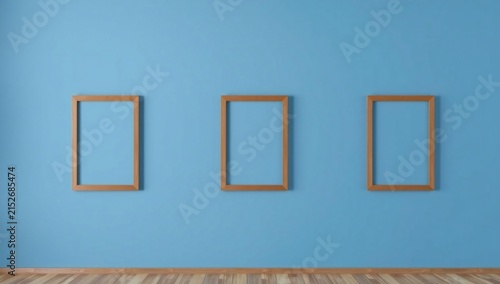 Three empty picture frames on blue wall