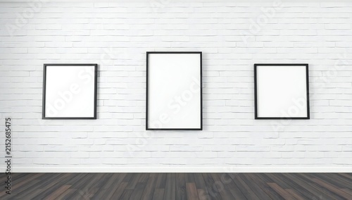 Three empty frames on white brick wall