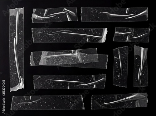 Set of clear plastic tape strips isolated on black background, transparent glossy adhesive tape for scrapbook, collage and design overlay