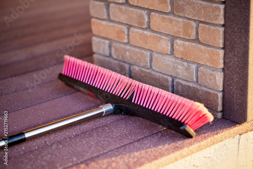 Stiff All Purpose Push Broom with Aluminum Handle laying on a Deck with Bristles facing Up