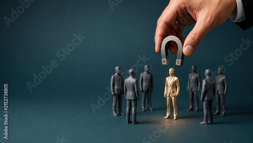 Talent acquisition strategy concept with businessman hand using magnet to attract unique golden candidate figure