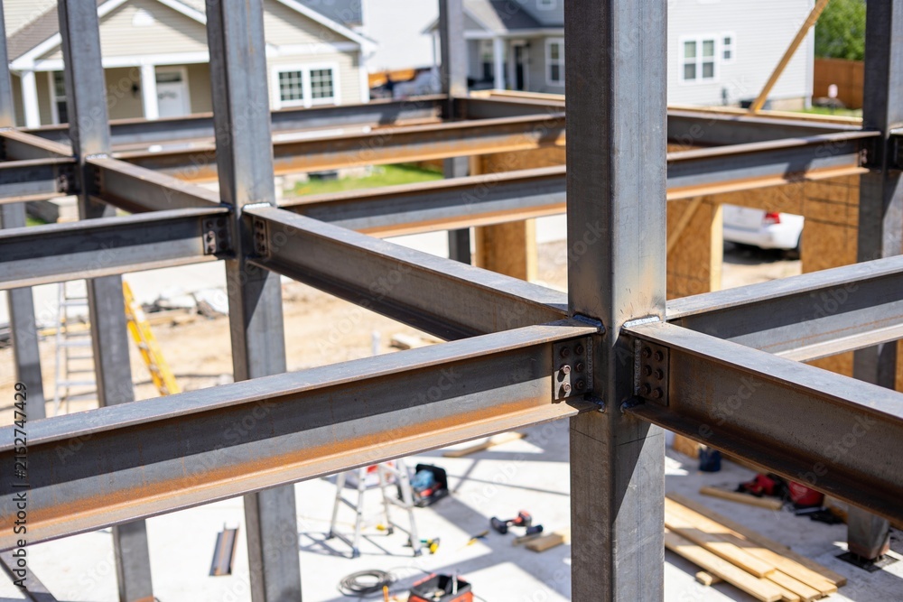 Fototapeta premium A close-up view of structural steel beams being assembled for a residential building construction.