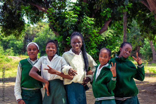 Happy African schoolchildren in uniforms enjoy a genuine moment of friendship and joy outdoors. A vibrant scene of education, unity, and shared learning, capturing the essence of daily school life.
