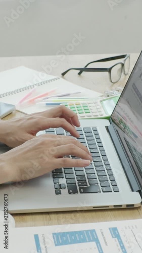 Close-up of Japanese businesswoman hands working on computer by window, vertical video