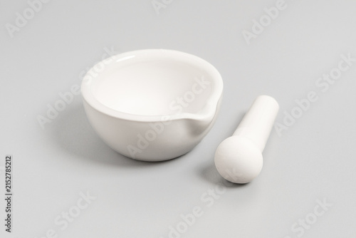 Fotografía Studio product photography of a white porcelain mortar bowl with the matching pestle placed next to it on a smooth light grey background