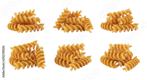 various uncooked spiral pasta piles on a white surface ingredients for italian cuisine and culinary concepts with isolated close-ups