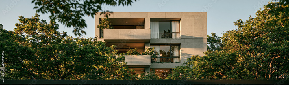 Fototapeta premium Modern Apartment Building Amidst Greenery: A contemporary concrete apartment building, featuring clean lines and balconies, is nestled amongst lush trees, blending urban living with nature.