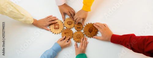 Картината върху платно This image captures a group of diverse hands collaborating to assemble wooden gear pieces, symbolizing unity, innovation, and the integration of artificial intelligence concepts in teamwork