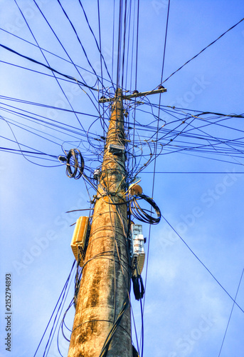 Tangled Electric and Telecommunication Wires on Concrete Utility Pole
