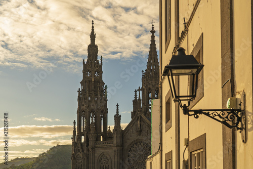 View of the neo-Gothic Church of San Juan Bautista with its intricate stone spires and facade under a warm sunset sky in Arucas, Canary Islands, Spain.