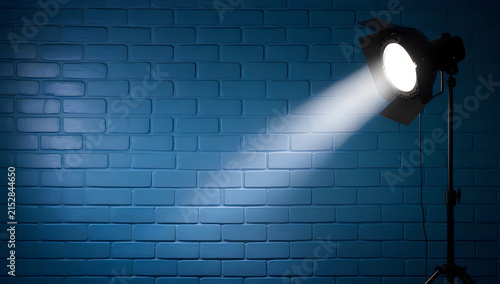 Bright spotlight shining on a blue brick wall illustration