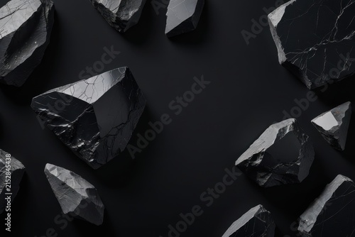 Close-up of black obsidian rocks with sharp edges and glossy reflective surfaces arranged on dark background, highlighting volcanic glass texture and striking natural detail.