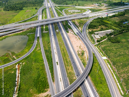 Drone shot a large highway interchange crossing over green farmlands in Thailand