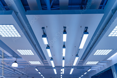 Directional LED lights on rails under the ceiling in a modern warehouse, shopping center building, office or other commercial real estate object.