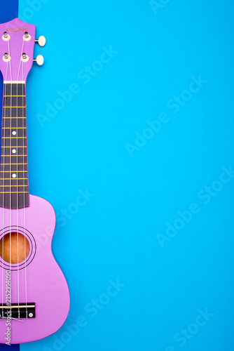 Foto Four string ukulele guitar on blue background