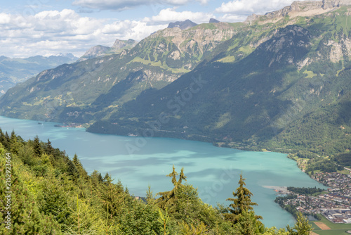 Fotografía Scenic landscape of Lake Brienz featuring vibrant turquoise blue-green water, alpine mountains, and charming lakeside settlements in the Bernese Oberland