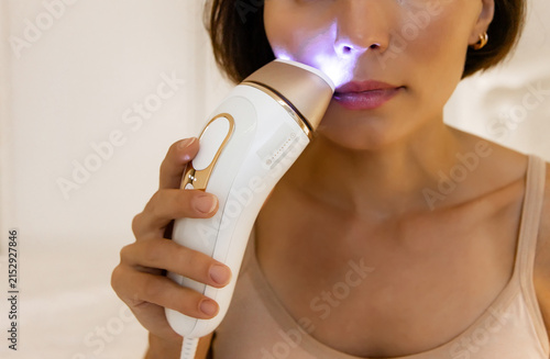 Obraz na plátne Macro Shot of Female Applying Precision IPL Epilator Head to Upper Lip Area for