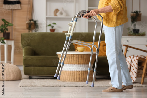 Senior woman using walker at home
