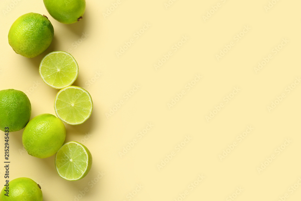 Fototapeta premium Fresh ripe limes on yellow background