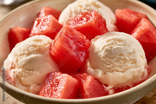 Three perfectly round scoops of creamy ice cream. Generous pieces of fresh, juicy, and tender watermelon, sliced ​​into neat cubes, are nestled between the scoops.