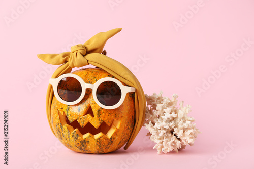 Konstfotografi Halloween pumpkin in sunglasses with seashell on pink background