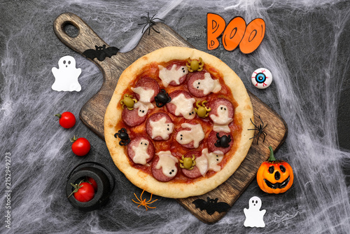 Foto Composition with tasty Halloween pizza, tomatoes and decorations on dark backgro
