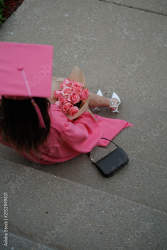 Canvastavla Graduation celebration with a graduate holding flowers on the steps in a pink go