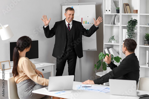 Male business consultant giving presentation to his colleagues in office