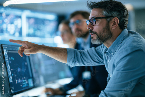 Technology manager collaborating with software team using AI powered project management dashboard