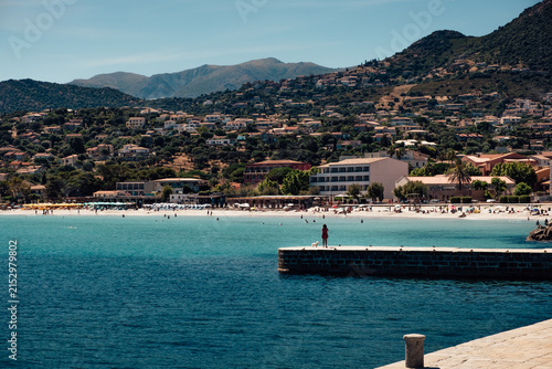 White sand beach of Ile-Rousse with the mountains behind in Corsica