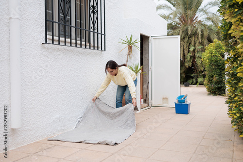 Woman preparing to paint exterior house wall