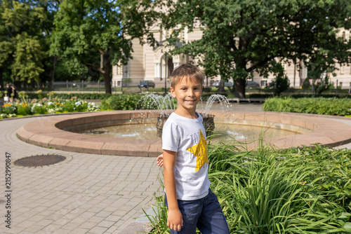 Foto Cute preschool child, boy walking along colorful cobblestone streets of Riga