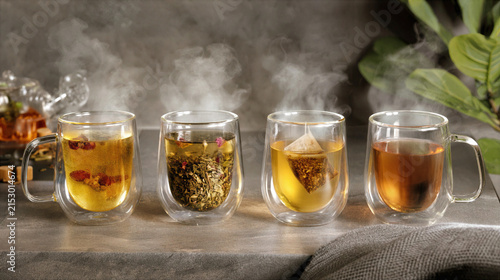 Steaming hot herbal tea clear double walled glass cups with natural ingredients and cozy setting