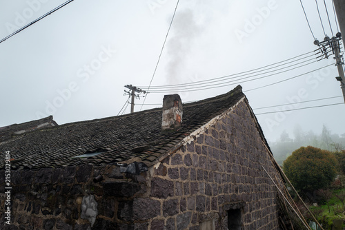 Old Stone House with Chimney in Foggy Rural Landscape
