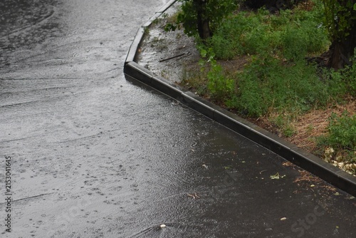 Rain in the city, raindrops on the asphalt. Rainy weather in summer 