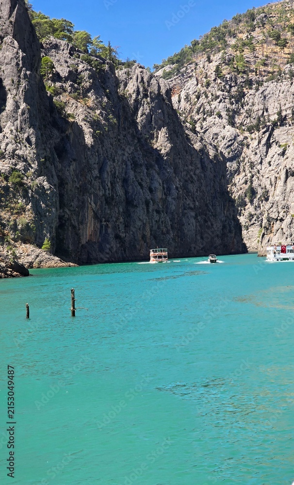 Obraz premium Touristic excursion boats sailing in a spectacular canyon with emerald green water