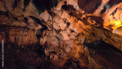 Fotografie Intricate prehistoric cave ceiling and stalactite structures highlighted by warm